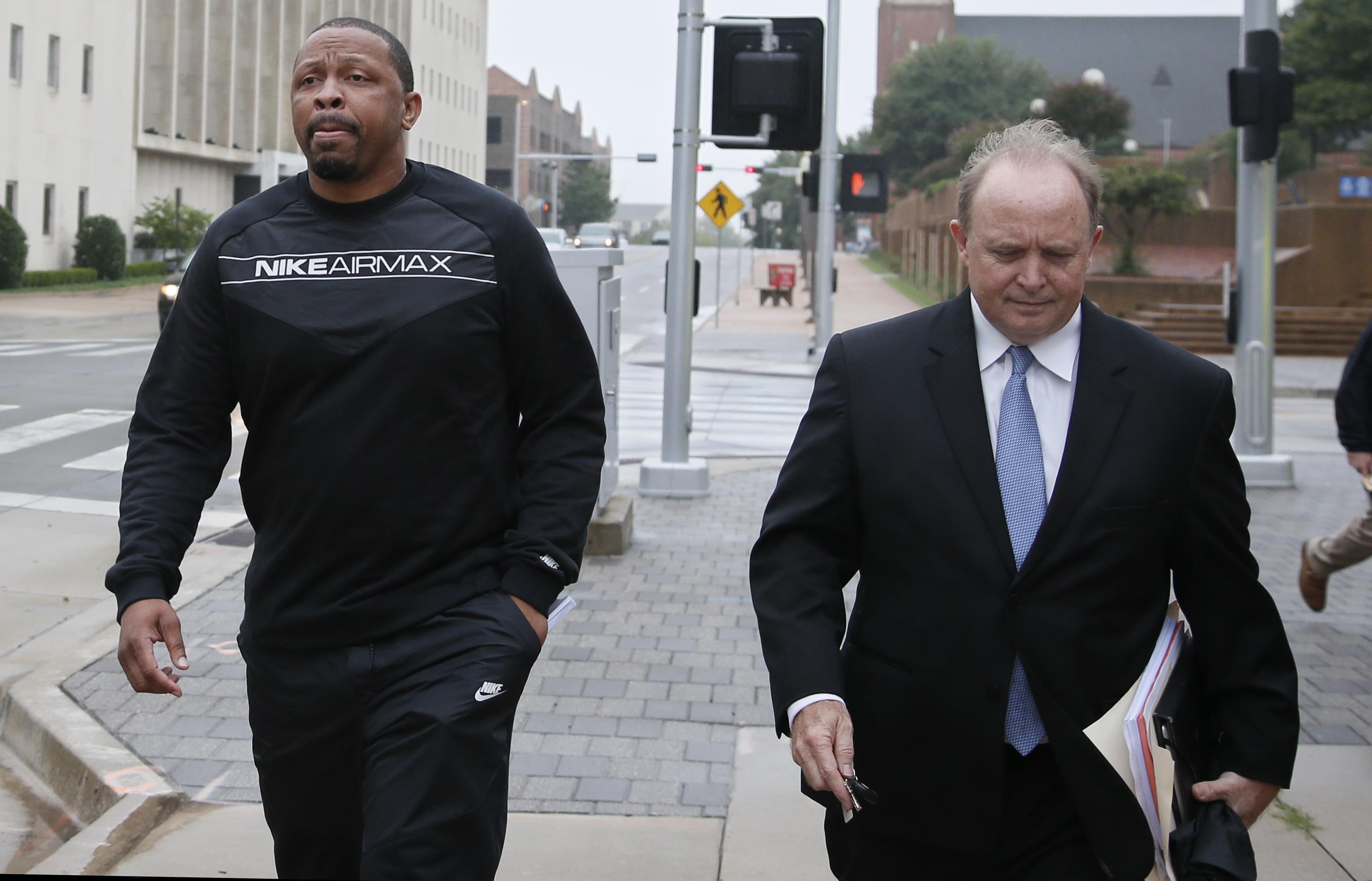 Lamont Evans, left, an assistant basketball coach at Oklahoma State University, and his attorney Trace Morgan leave the federal courthouse following a court appearance in Oklahoma City, Wednesday, Sept. 27, 2017.