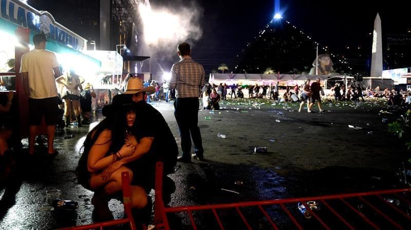 People take cover at the Route 91 Harvest country music festival after a gunman opened fire on the festival from a room in the Mandalay Bay Resort and Casino in Las Vegas, Nevada. 
