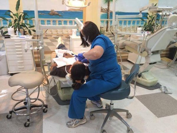 A hygienist numbs a patient in preparation for a tooth extraction at Smiles of Hope.