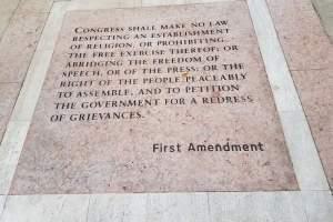 The First Amendment Words written on a sidewalk. 