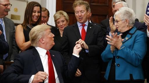 President Donald Trump hands a pen that he used to sign an executive order on health care to Sen. Rand Paul, R-Ky., in the Roosevelt Room of the White House on Thursday.