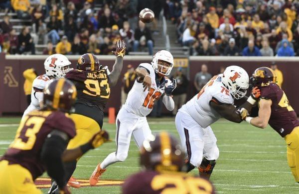 Illinois quarterback Cam Thomas stiff arms Minnesota defensive back Duke McGhee as he rushes for a first down.