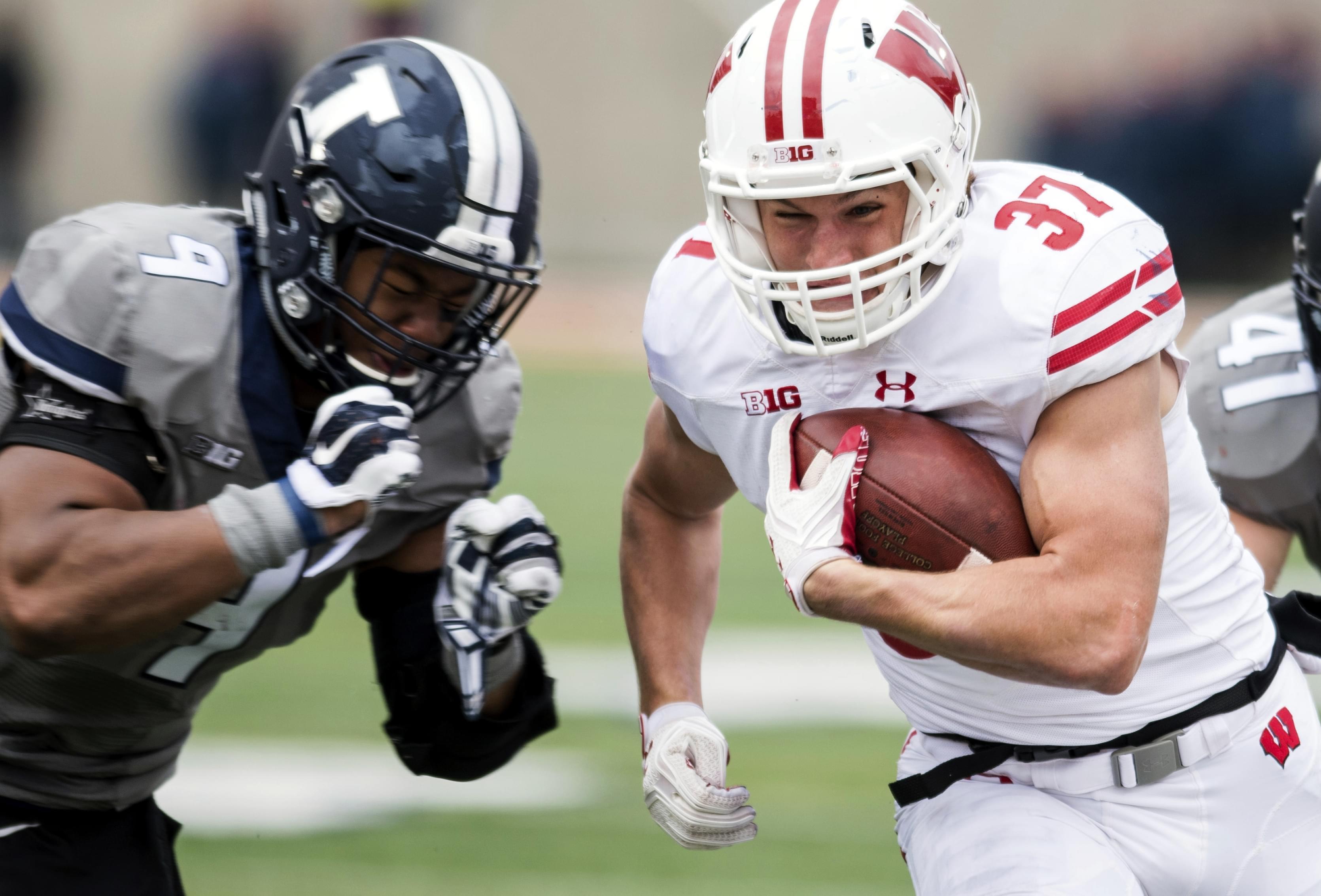 Wisconsin running back Garrett Groshek tries to avoid a tackle by Illinois linebacker Dele Harding.