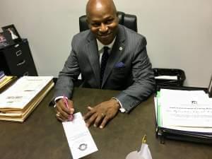 State Rep. Emanuel Chris Welch demonstrates his own penmanship on the House calendar after his cursive bill became law.