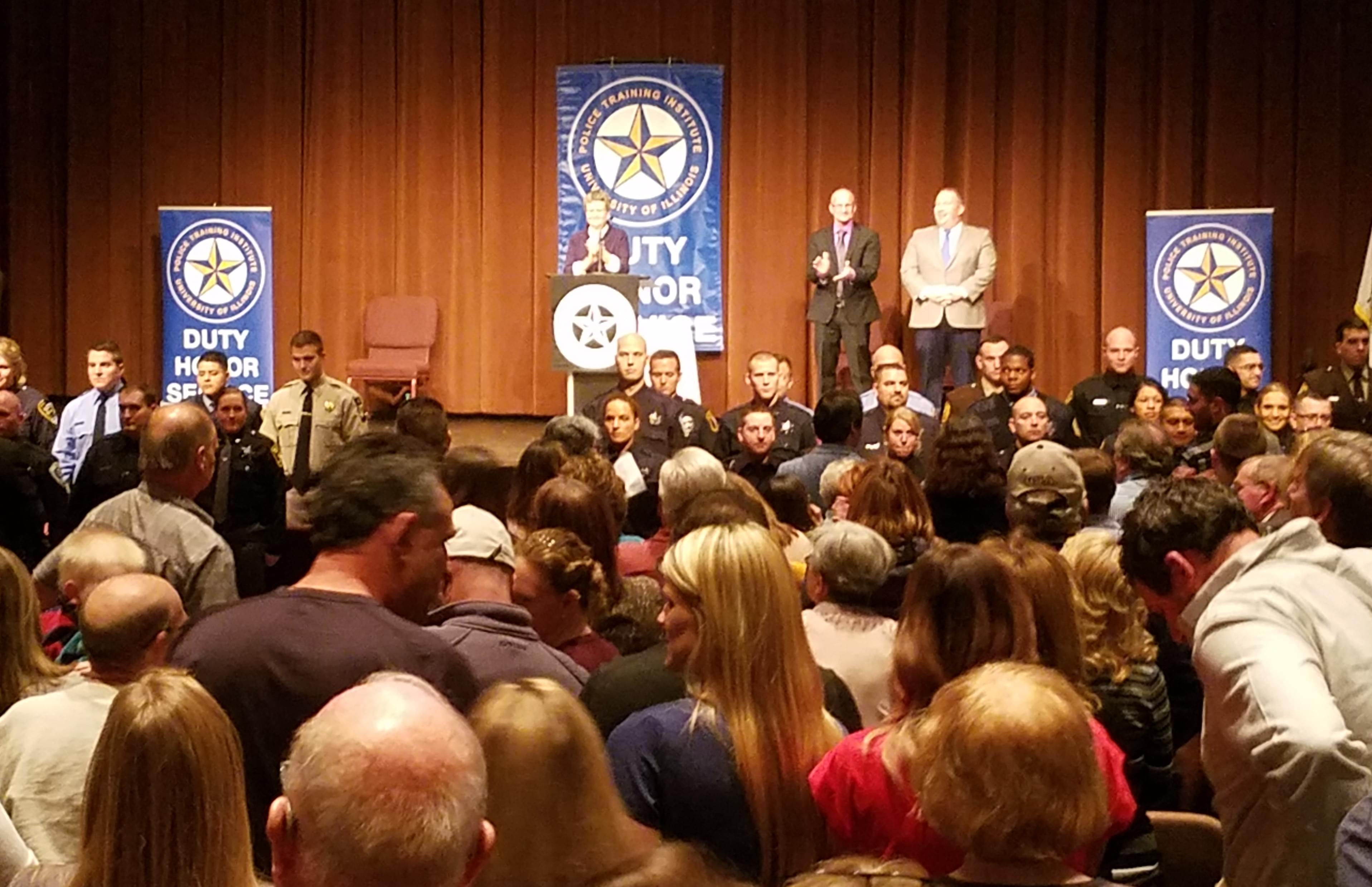 An dueince applauds the graduating class at the graduation ceremony for the University of Illinois Police Training Institute.