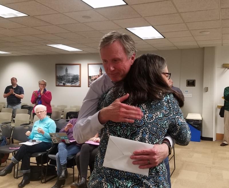 Champaign County Treasurer Dan Welch receives a hug from County Board member Diane Michaels.