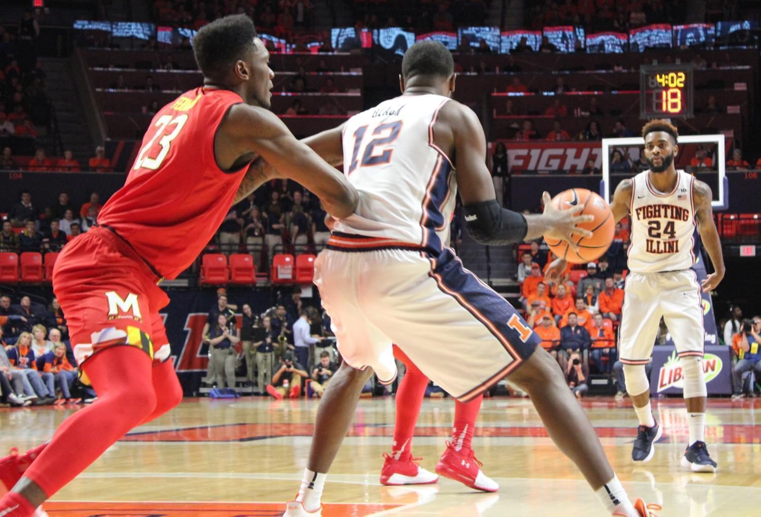 Illinois' Mark Alstork (24) passes to Leron Black (12) during a 92-91 overtime loss to Maryland Sunday night in Champaign.
