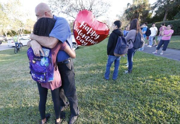 Family members, one of them holding a heart-shaped Valentine's Day balloon, embrace following a shooting at Marjory Stoneman Douglas High School, in Parkland, Florida on Wednesday. 