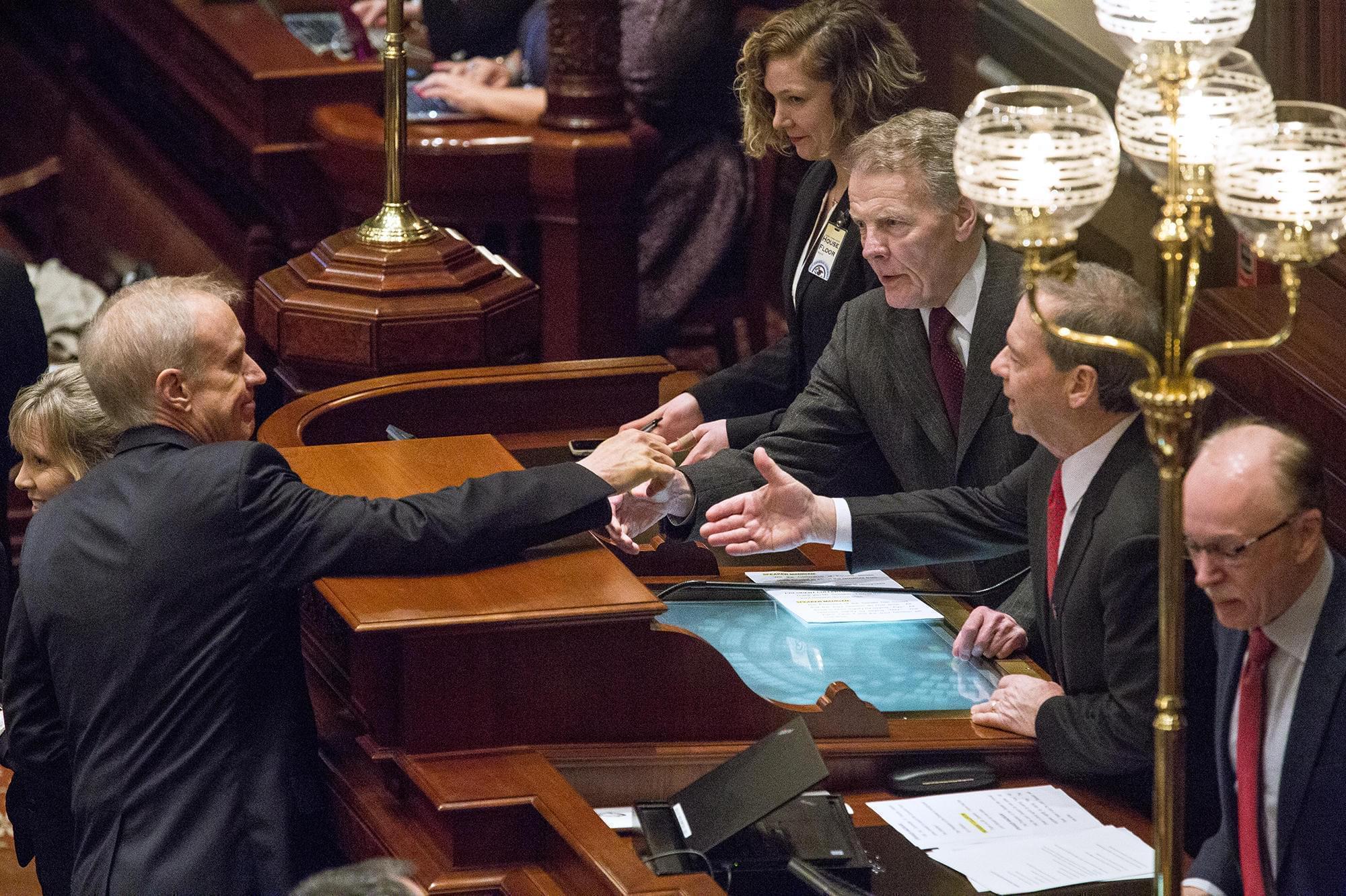 Gov. Bruce Rauner shakes hands with House Speaker Michael Madigan, left, and Senate President John Cullerton.