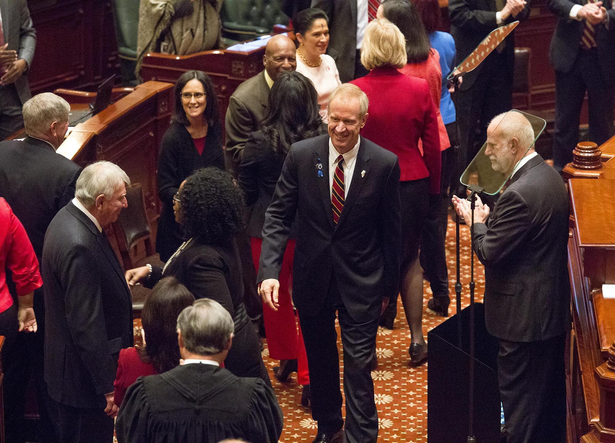 Gov. Bruce Rauner greets Illinois officials before his annual budget address Wednesday.