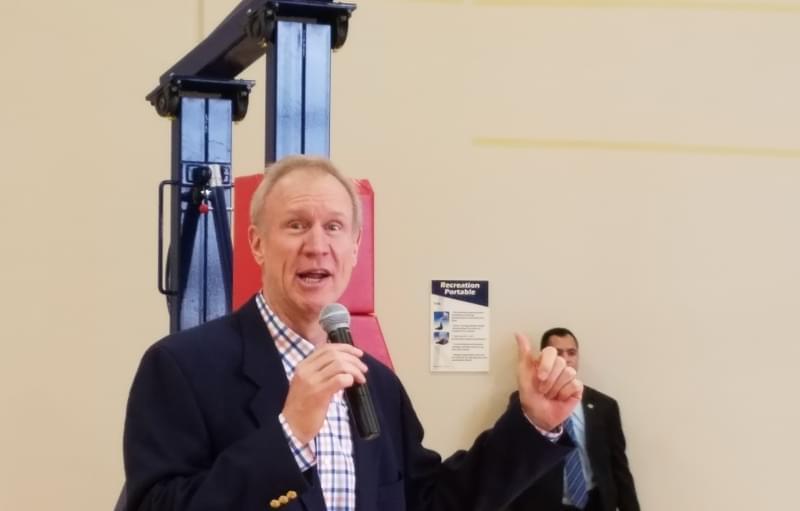 Gov. Bruce Rauner talks to employees at the Litania Sports Group athletic equipment company in Champaign.