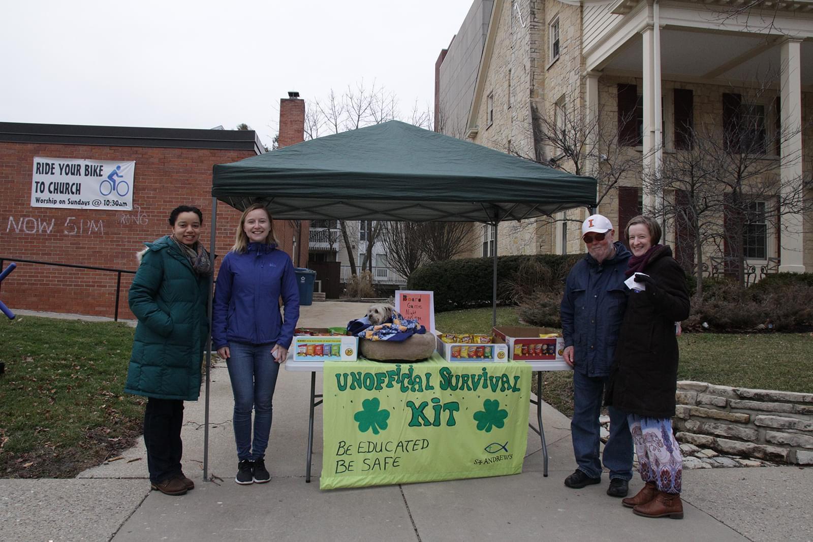 Volunteers hand out snacks and information about alternatives to 'Unofficial' outside St. Andrew's Lutheran Campus Center on Wright Street.