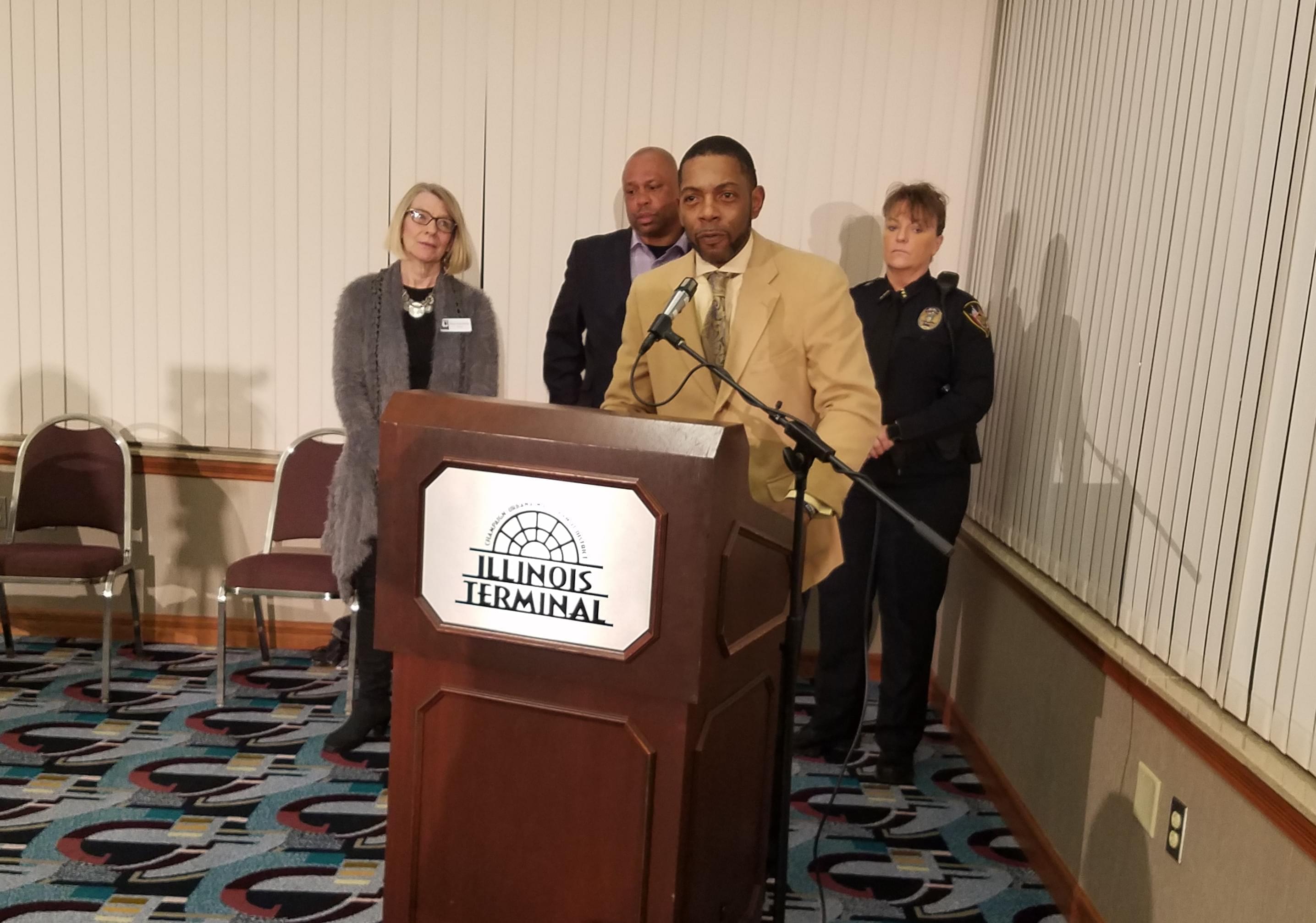 Champaign barber and funeral director Seon Williams, flanked by Urbana Mayor Diane Marlin, Tracy Parsons with the city of Champaign, and Urbana Police Chief Sylvia Morgan.