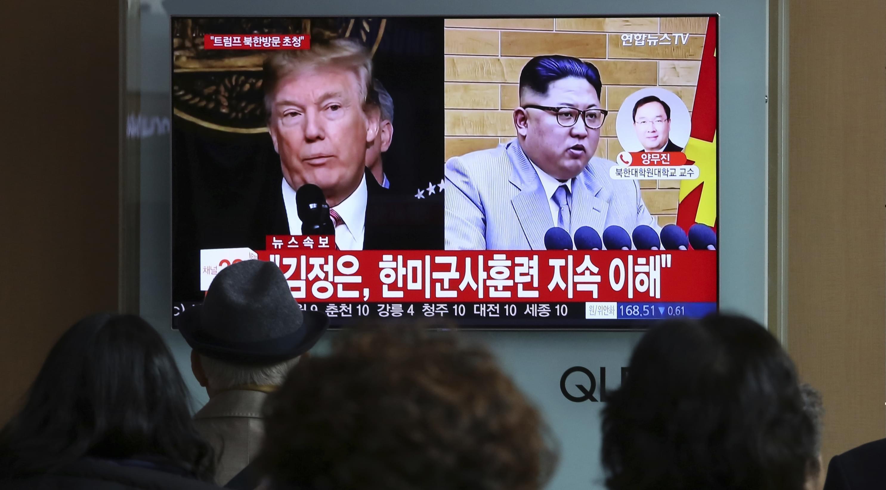 People watch a TV screen showing North Korean leader Kim Jong Un and U.S. President Donald Trump at the Seoul Railway Station in Seoul, South Korea, Friday, March 9.The headlines on the TV screen reads: " Kim Jong Un understands that the routine