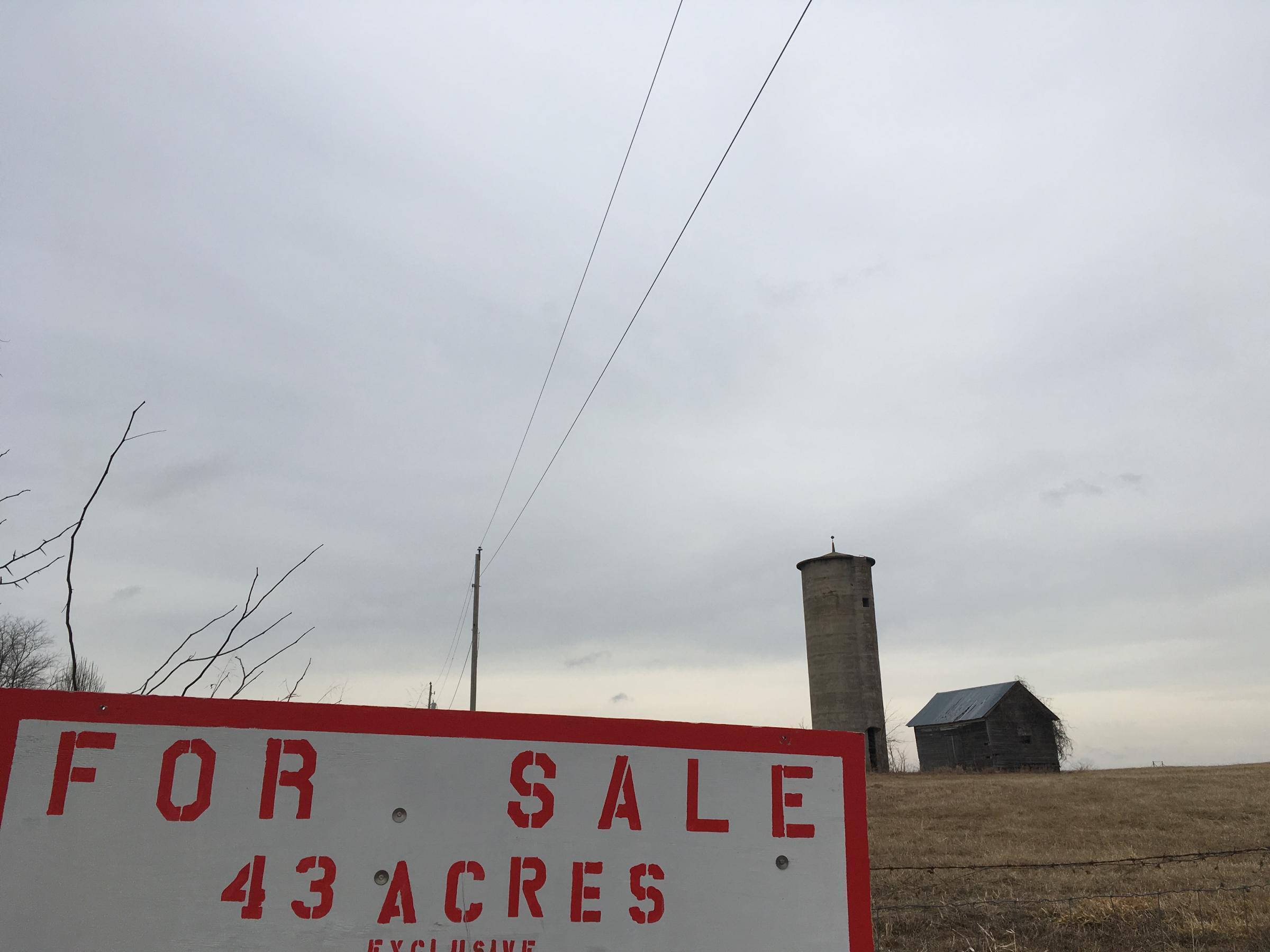 Farm buildings sit on land that's for sale in Clay County, Missouri. Nearly 40,000 people have moved to the county since 2000.