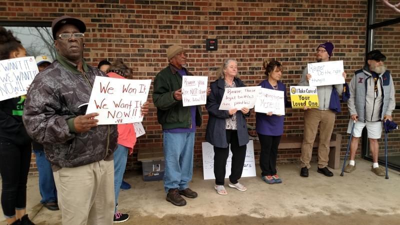 Members of SEIU Healthcare Illinois, the union representing personal assistants who provide in-home care to people with disabilities, hold signs in front of the Champaign office for the Illinois Department of Human Services on March 29, 2018.