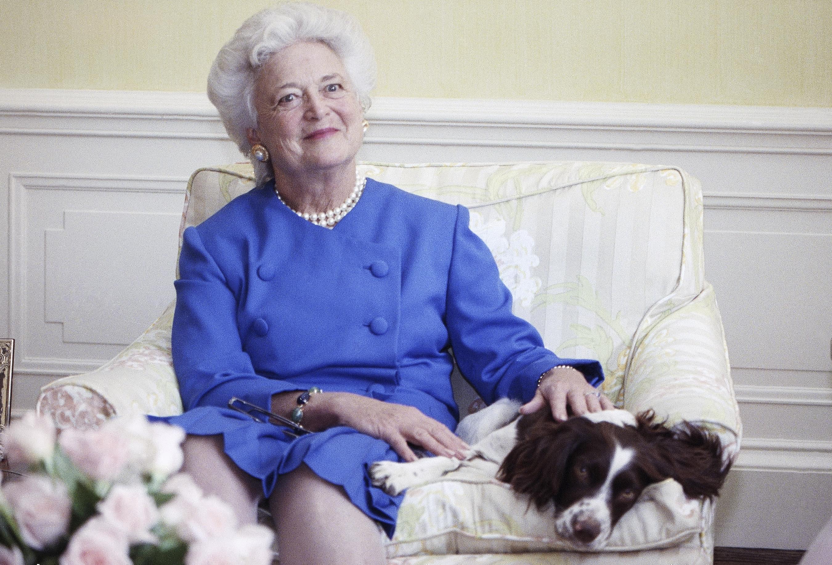Barbara Bush, posing with her dog Millie in 1990.