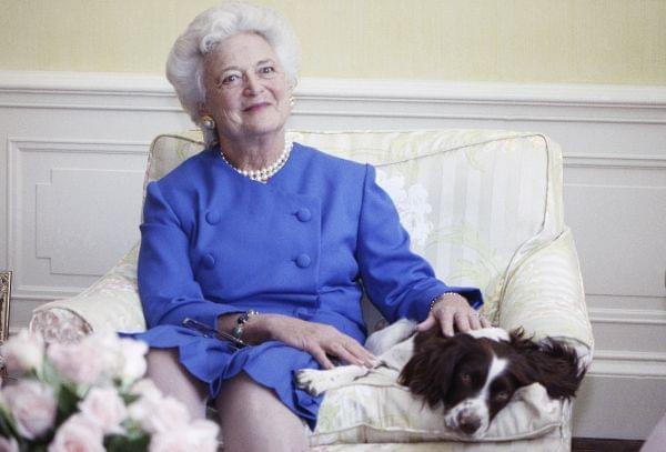 Barbara Bush, posing with her dog Millie in 1990.