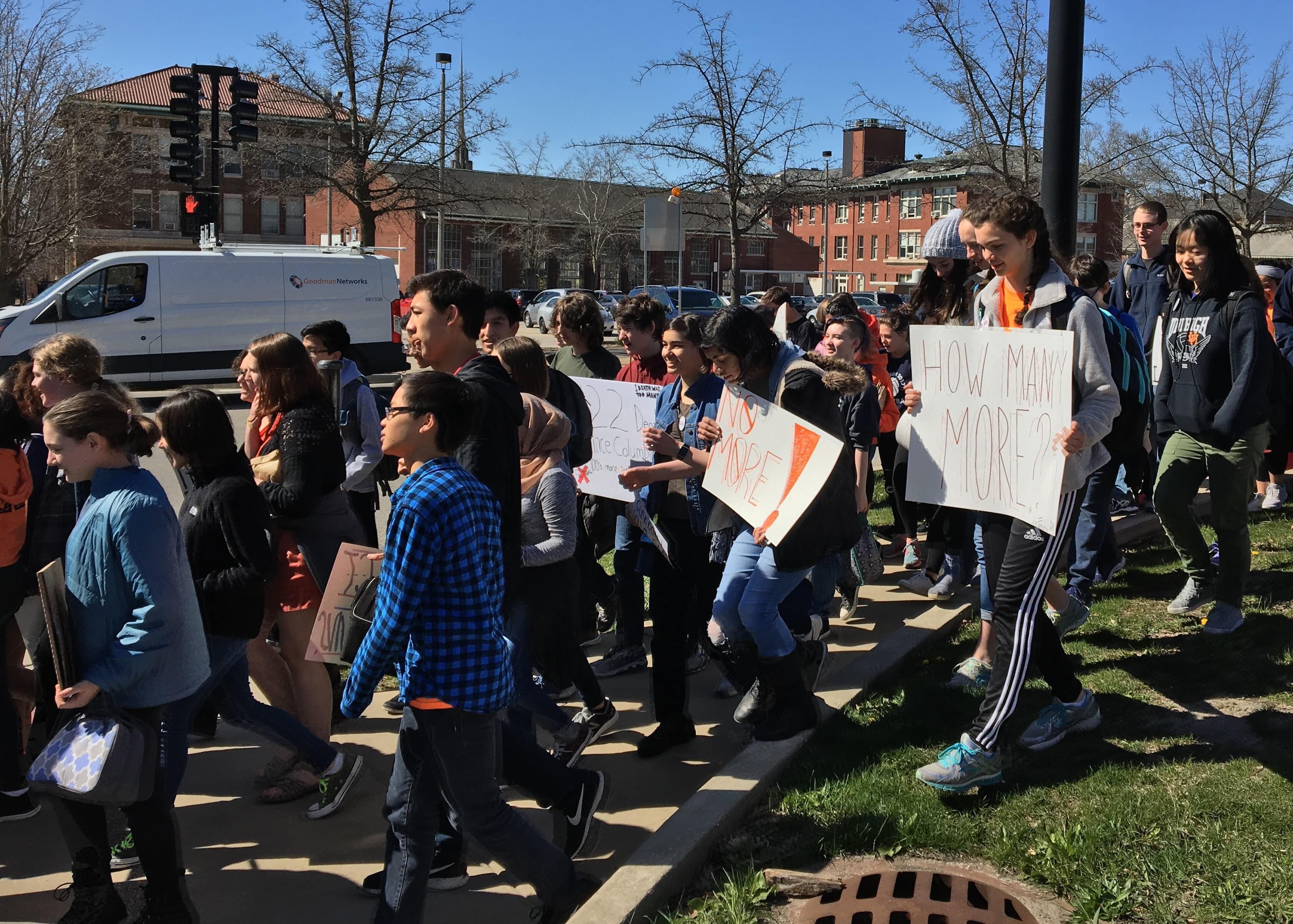 Uni High Students marching and displaying signs advocating for gun reform. 