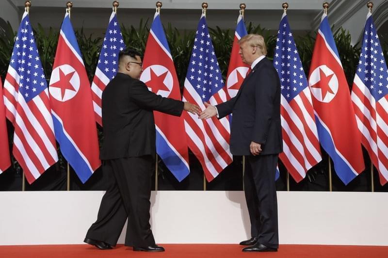 North Korean leader Kim Jong Un reaches to shake President Trump's hand at the Capella resort on Sentosa Island in Singapore on Tuesday.