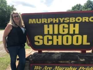 Murphysboro High School teacher Stacie Tefft stands next to a sign for the high school. 