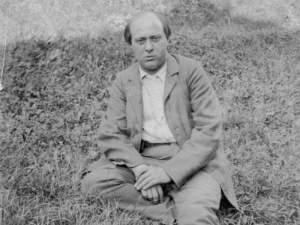 Composer Arnold Schönberg sitting on ground
