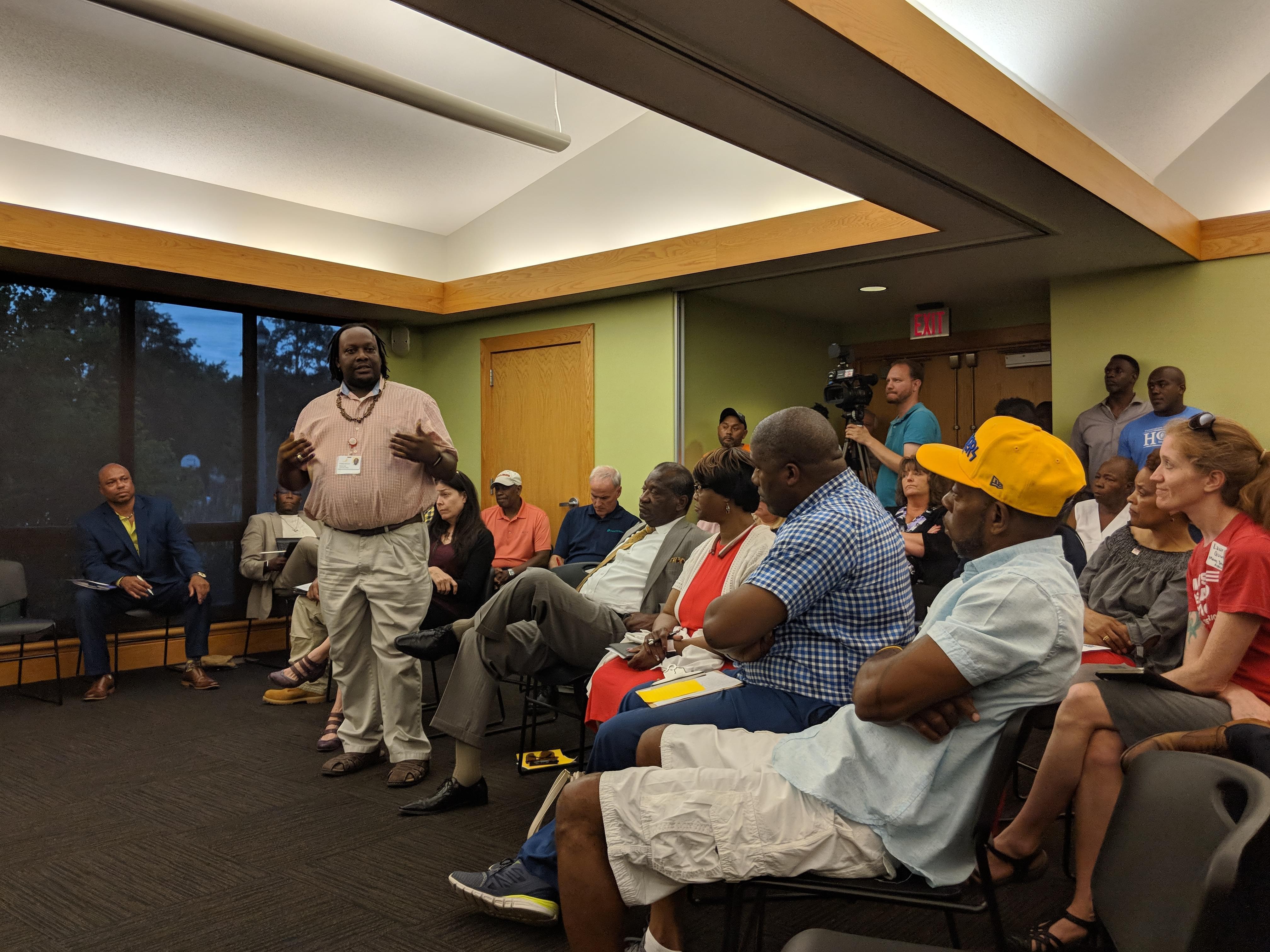 Donte' Lotts of CU Fresh Start speaks in front of a crowd of people at the Douglass branch library.