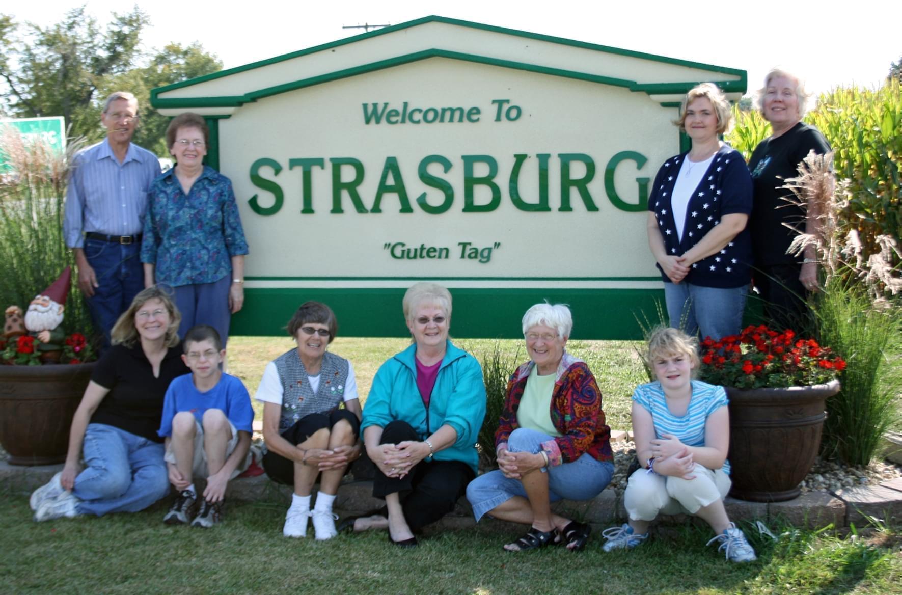 Residents gathered around Strasburg welcome sign.