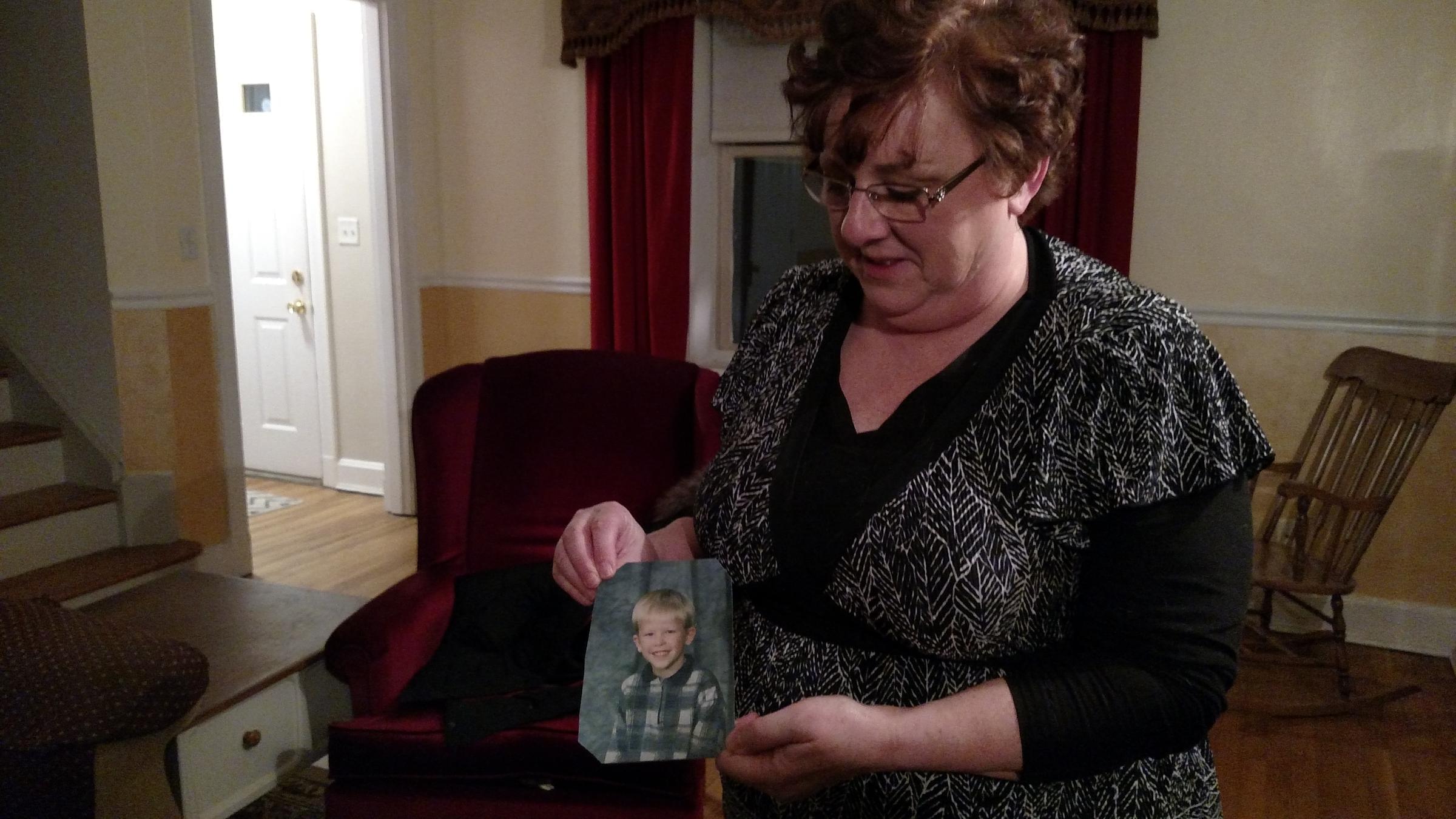 Toni Hoy holds a picture of her son, Daniel, at her home in Rantoul, Illinois. In a last-ditch effort to get Daniel treatment for his severe mental illness, they gave him up to the state in 2008, when he was 12.