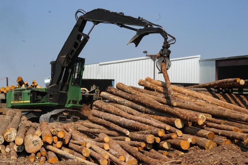 A machine piles pine logs for processing at the Montrose Forest Products sawmill. In 2012, this Colorado log yard was nearly empty.