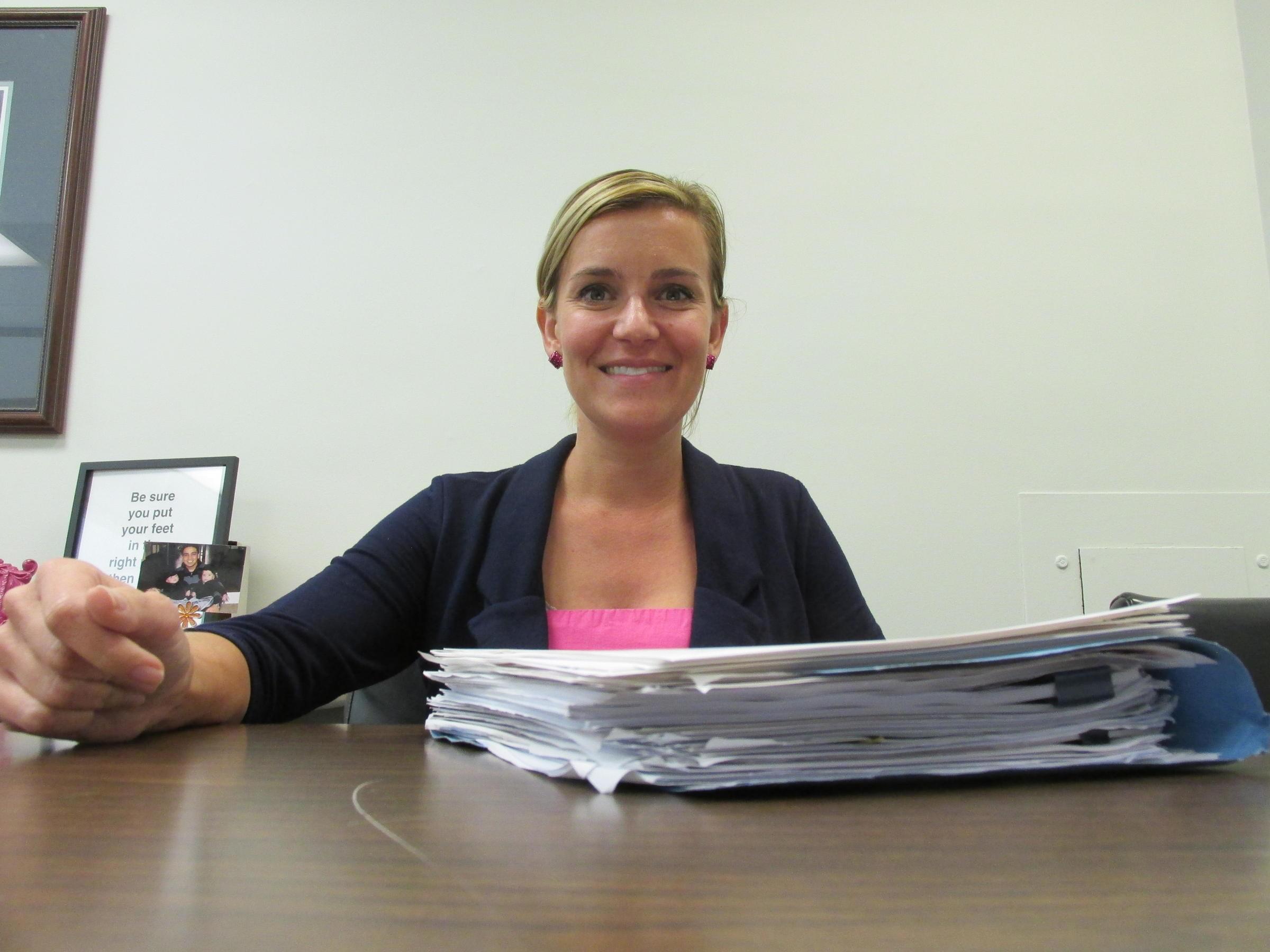 State Rep. Sara Wojcicki Jimenez sits behind a stack of reports and findings related to the House Sexual Discrimination and Harassment Task Force.