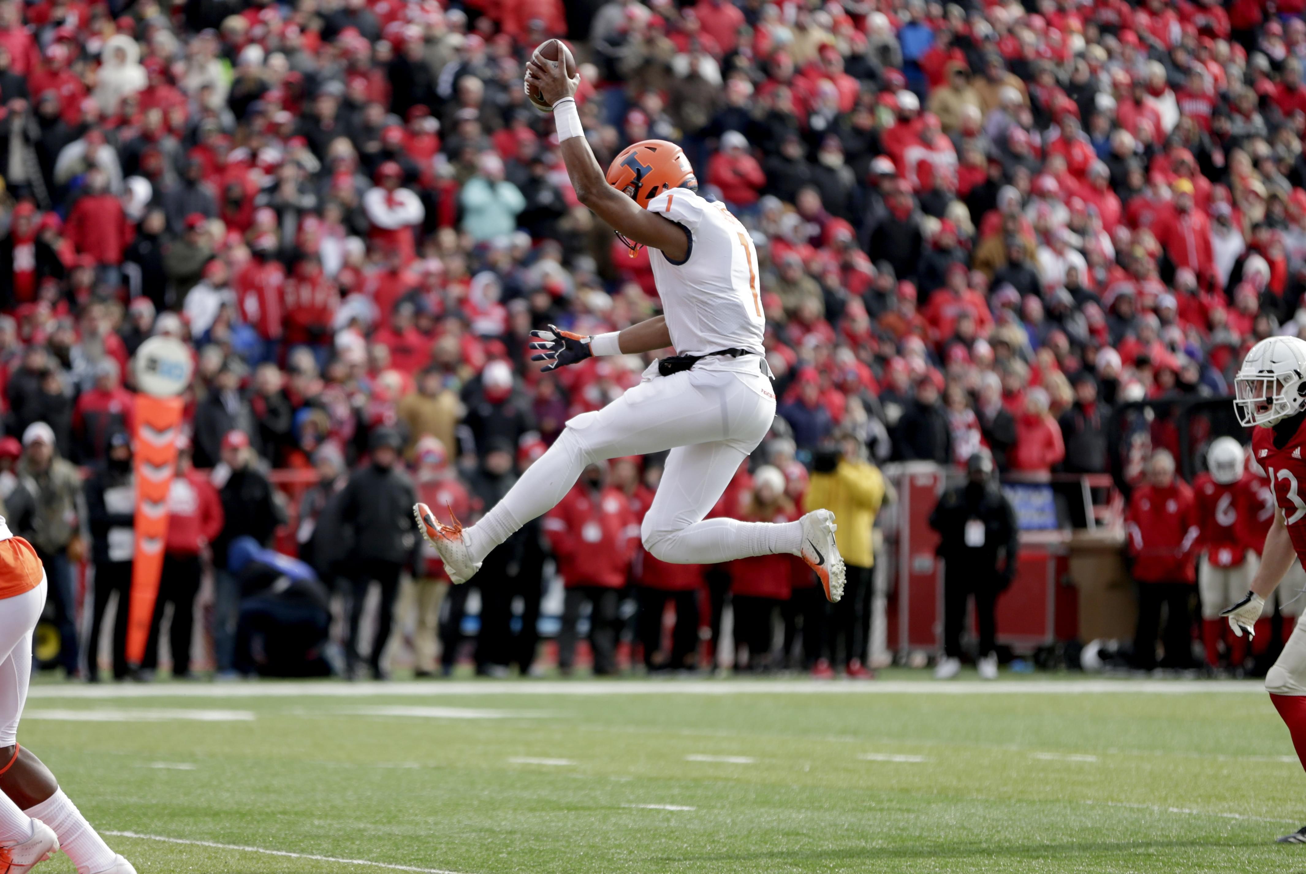 Illinois quarterback AJ Bush Jr leaps inito the end zone for a touchdown. 