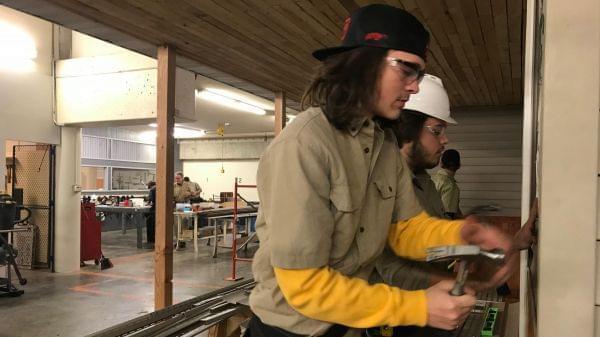 Shelby Landers and Matthew Mangold, both students at Capital Area Career Center, nail siding to the front of the house they're building in the trades class. Landers says he's happy to get out of the classroom and get more handson experience