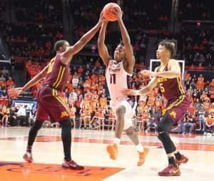 Ayo Dosunmu maneuvers between a pair of Golden Gophers during Illinois' 95-68 win, Wednesday in Champaign.