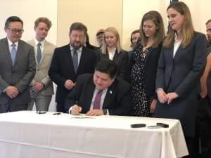 Surrounded by environmental advocates, Gov. J.B. Pritzker signs and executive order making Illinois the 18th state to join the U.S. Climate Alliance on January 23, 2019. 