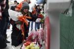 People pray at a makeshift memorial Sunday, Feb. 17, 2019, in Aurora, Ill., near Henry Pratt Co. manufacturing company where several were killed on Friday. Authorities say an initial background check five years ago failed to flag an out-of-state felo