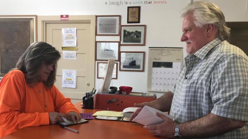Windy Fultz pays rent for her apartment at Mitchell Court in Rantoul, Illinois. She and the property manager, Stan James, talked about the new rules the village adopted to reduce crime.