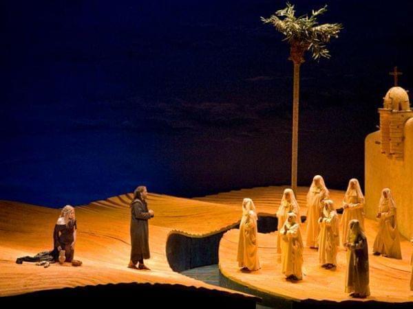 people perform on a desert scene on stage
