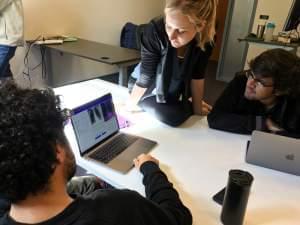 Amir Kiani (from left), Chloe O'Connell and Nishit Asnani troubleshoot an algorithm to diagnose tuberculosis in computer lab at Stanford University.
