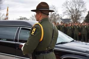 An Illinois state trooper prepares to approach the family of Trooper Brooke Jones-Story after her funeral ended in Warren, Ill.