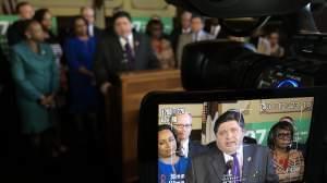 Gov. J.B. Pritzker, surrounded by Democratic lawmakers, spoke with reporters after the formal introduction of the constitutional amendment needed to advance his graduated income tax proposal.