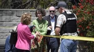 Synagogue members stand behind police tape talking to a deputy from the San Diego County Sheriff's department.