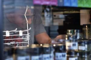 Logan Chase arranges CBD products in a glass case display. 