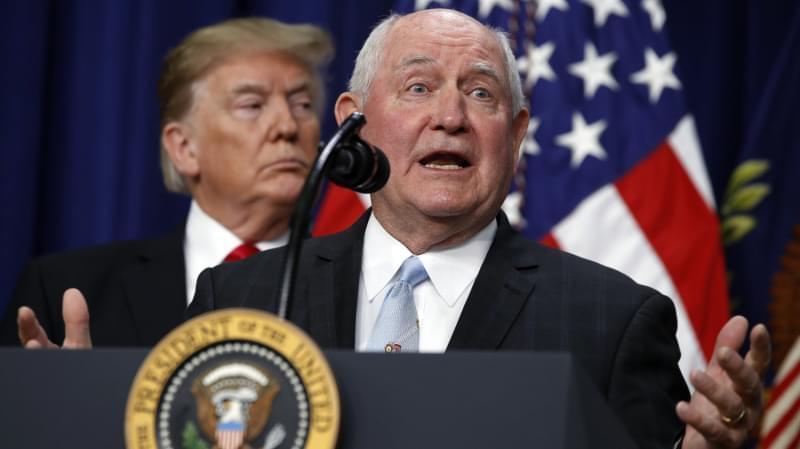President Trump listens to Agriculture Secretary Sonny Perdue during a signing ceremony. 
