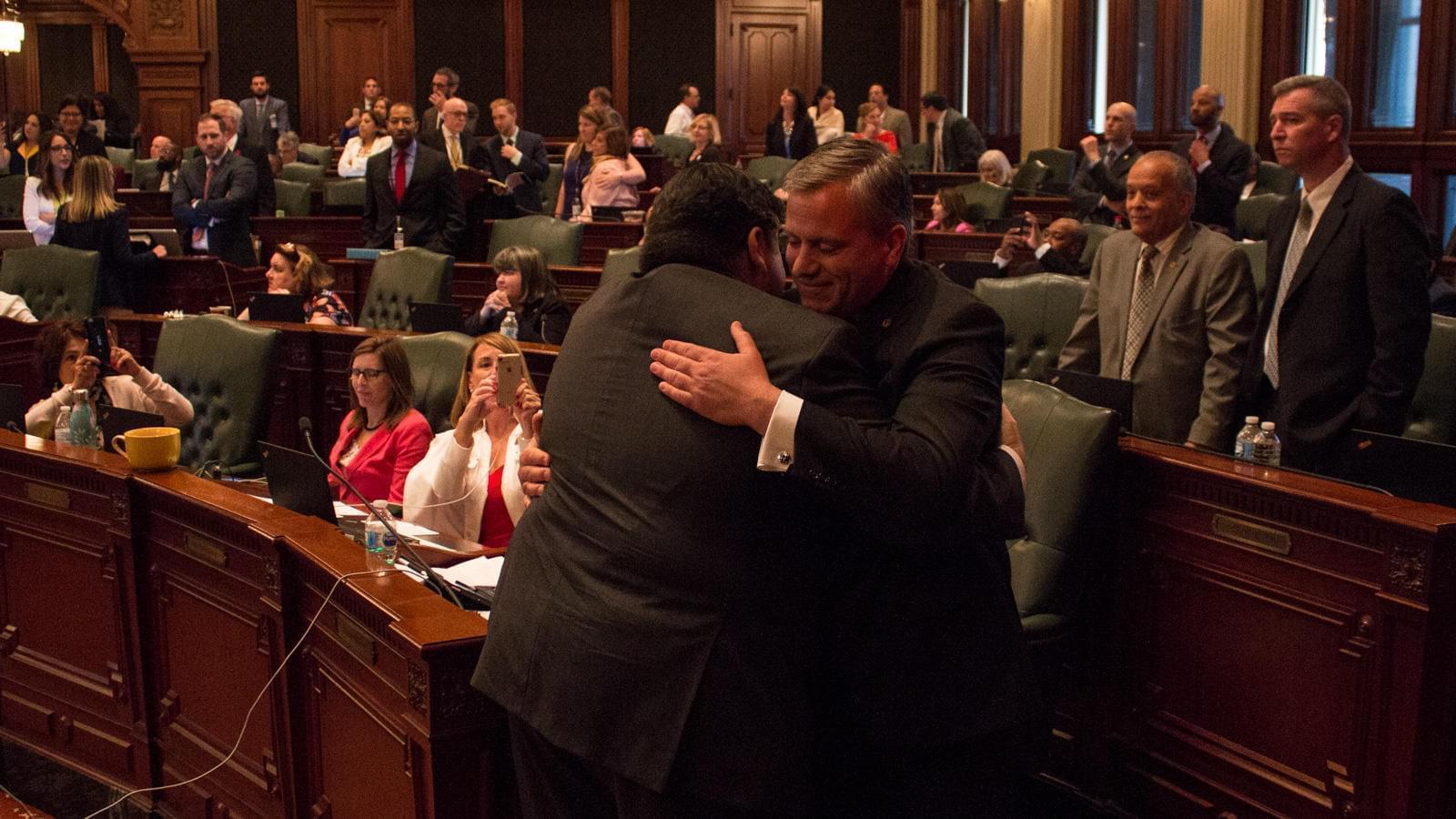 Gov. J.B. Pritzker, left, hugs state Rep. Robert Martwick after passage of a constitutional amendment to allow for a graduated income tax in Illinois.