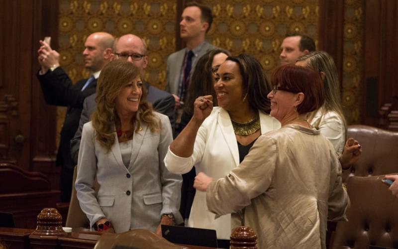 Illinois state Senators celebrate the passage of legislation to legalize marijuana. The lead sponsors were Sens. Heather Steans, right, and Toi Hutchinson, center. 