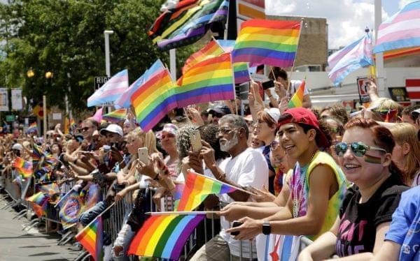 A crowd holds rainbow flags as they watch the 48th Annual Chicago Pride Parade on Sunday, June 25, 2017 in Chicago.