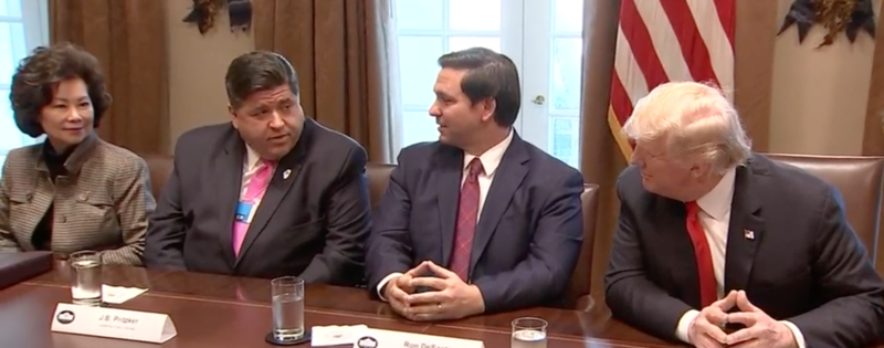 J.B. Pritzker and others seated at a table with President Donald Trump in the White House