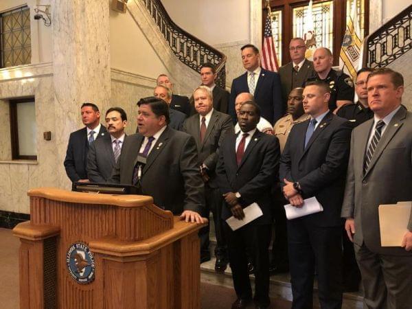 Governor J.B. Pritzker flanked by state lawmakers, unveils a bill raising penalties for Scott's Law violators at a ceremony in May. At far right, Acting State Police Director Brenden Kelly.