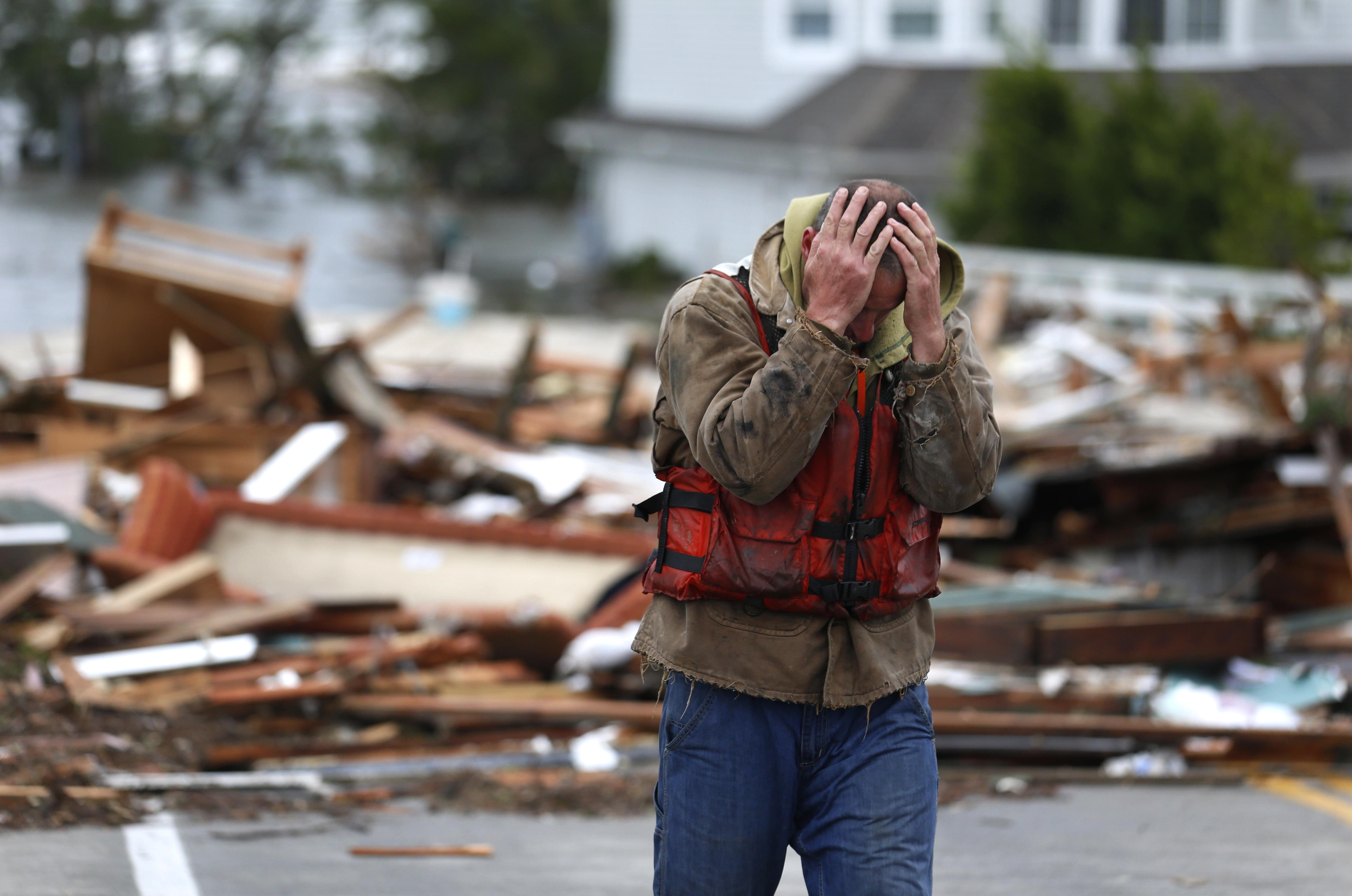 Brian Hajeski, 41, of Brick, N.J., reacts after looking at debris of a home that washed up on to the Mantoloking Bridge the morning after superstorm Sandy rolled through, Tuesday, Oct. 30, 2012, in Mantoloking, N.J.